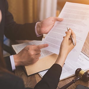 Two people reviewing a legal document discuss general counsel