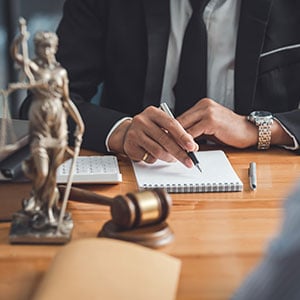 Business Law Attorney writing notes at a desk