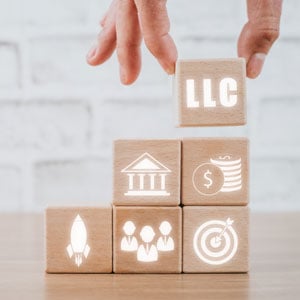 Building blocks with LLC symbol, representing startup protection from liability